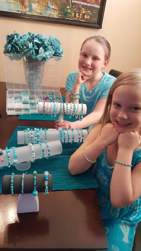 Danica and Delaney wearing their handmade teal bead bracelets
