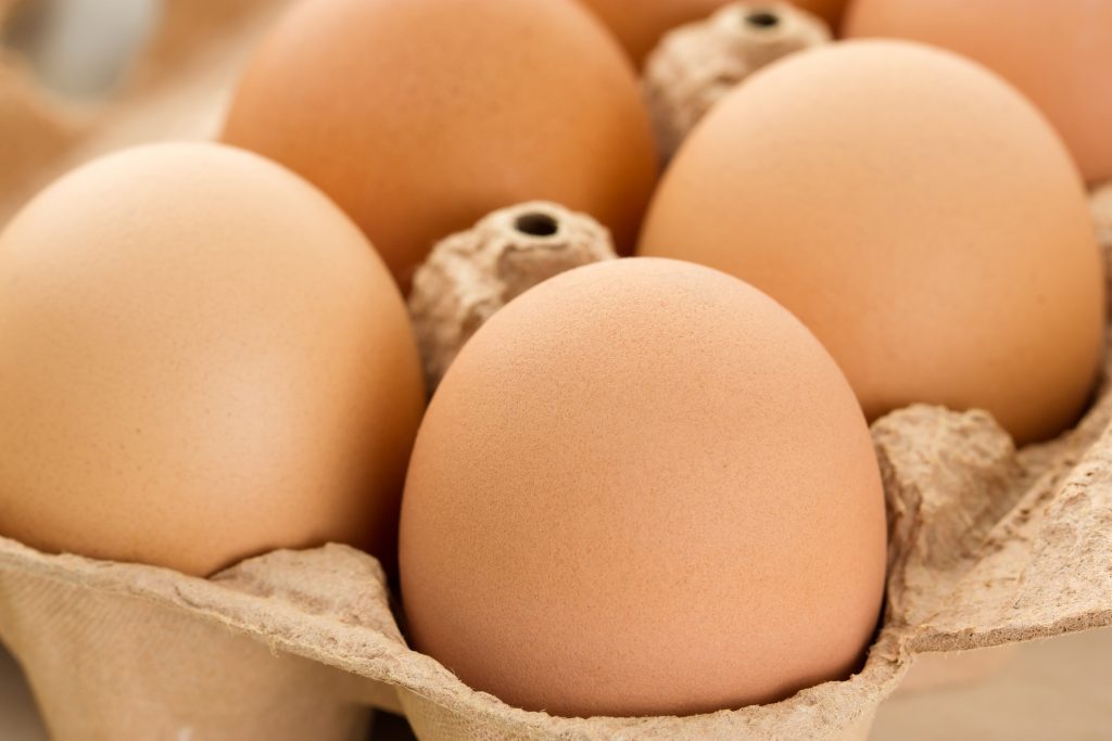 Close-up of brown eggs in egg box