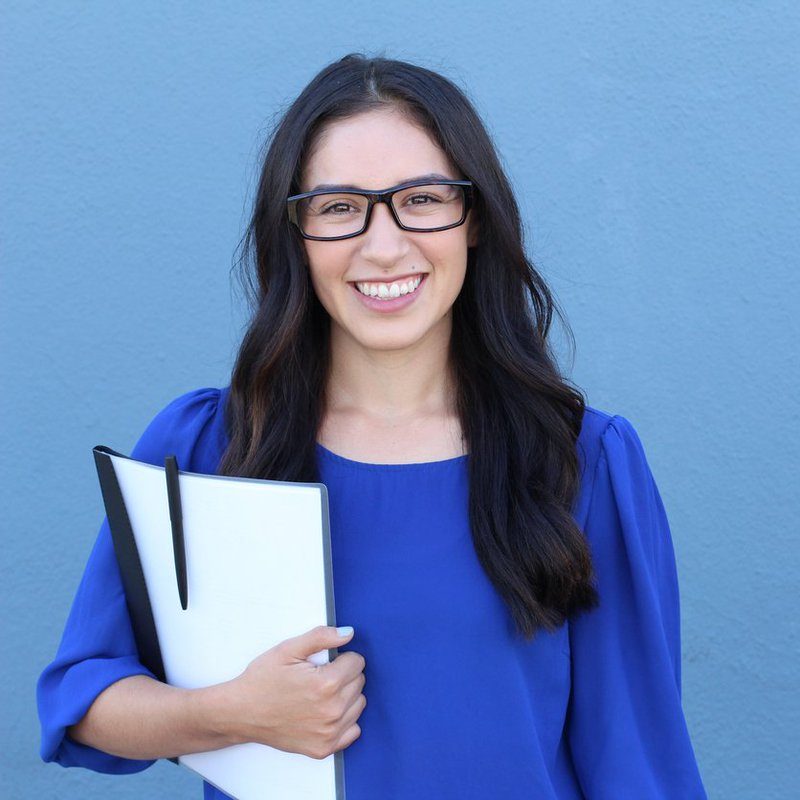 Graduate student smiling holding a folder
