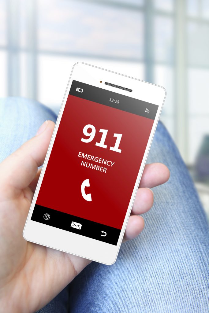 hand holding mobile phone with emergency number 911.