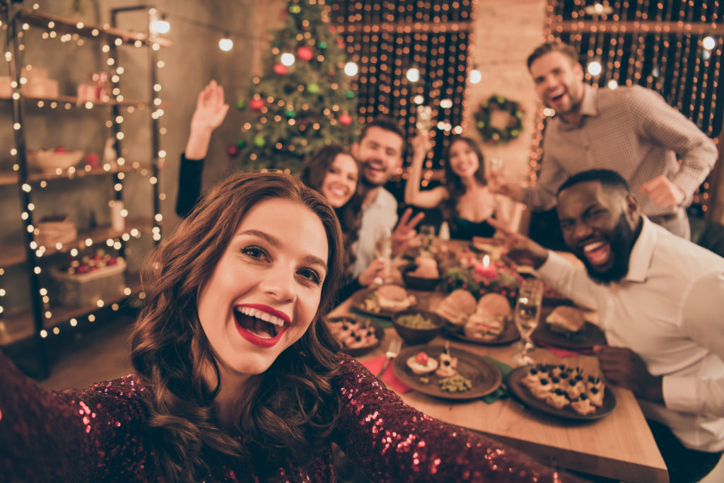 Close up photo of young adults around a table for a holiday party