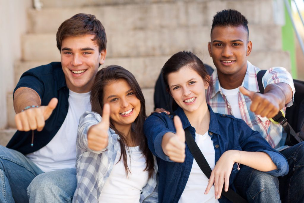 Group of teens giving a thumbs up to the camera