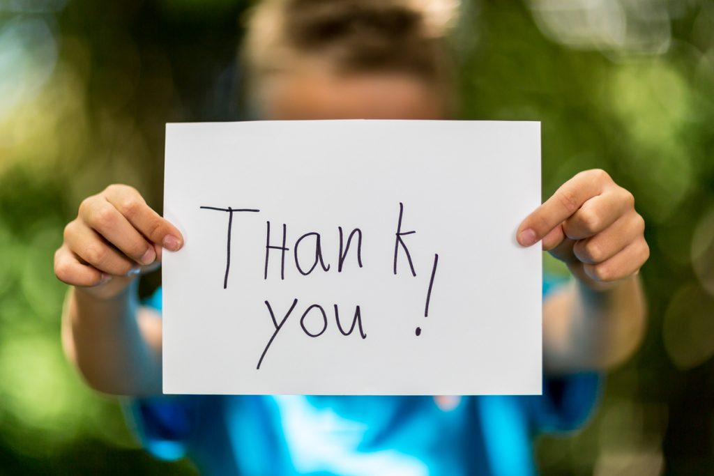 Child holding a thank you sign