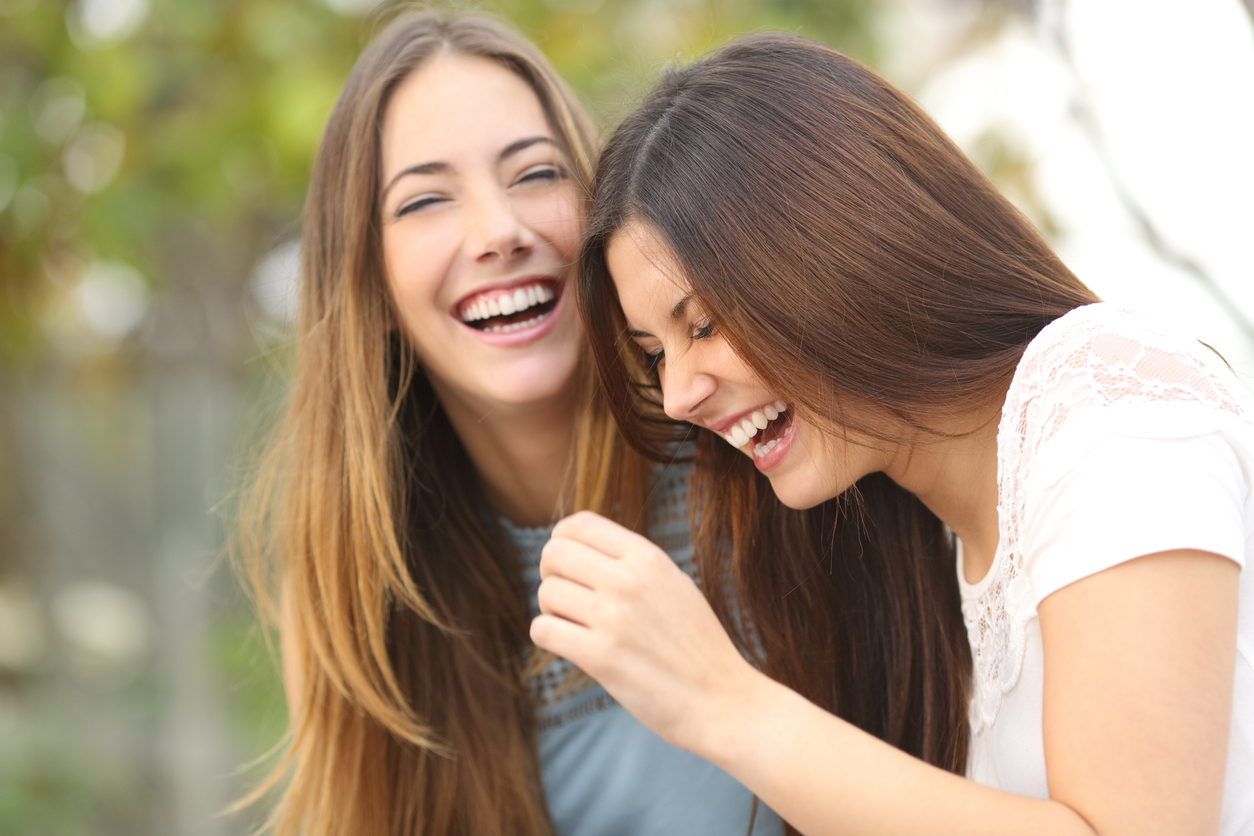 Two happy woman friends laughing