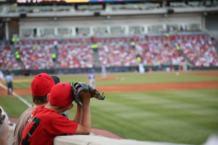 Two young boys hoping to catch a fly ball at a Cincinnati Reds baseball game