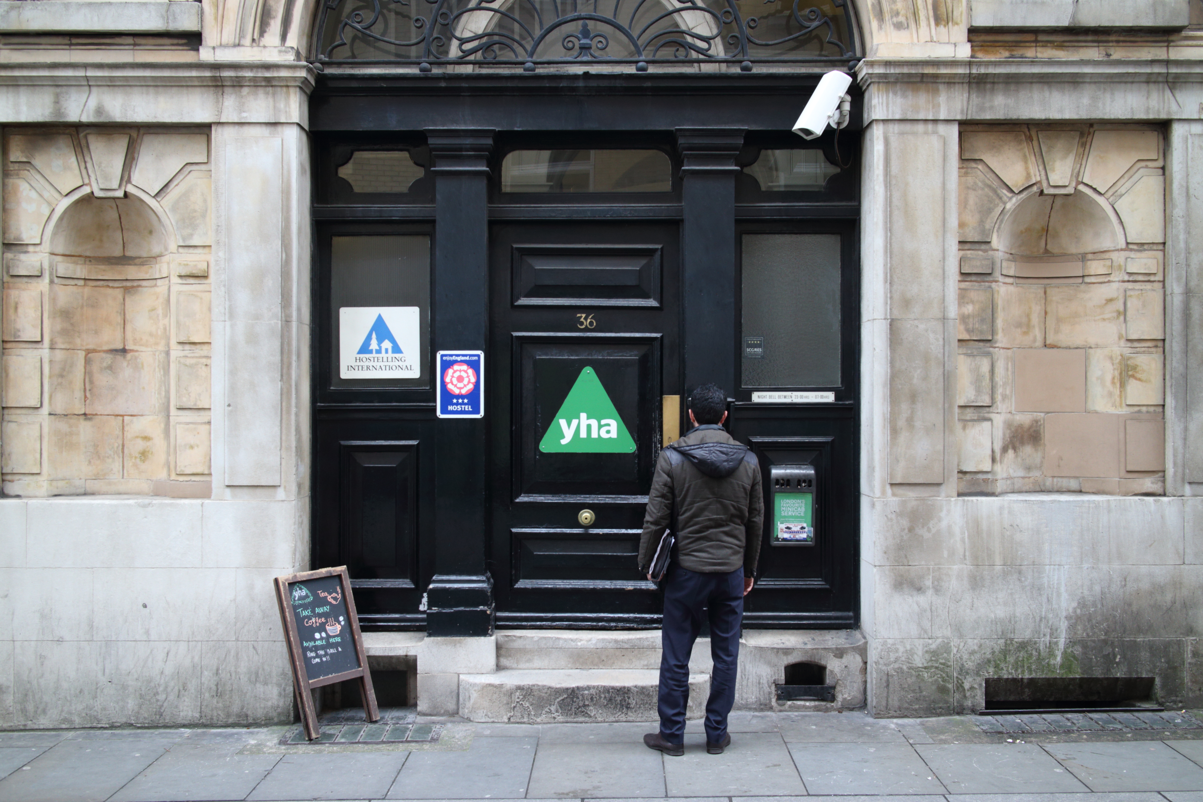 London, United Kingdom - March 17, 2015: A man at the entrance of the St Pauls Youth Hostel in London, England. The Youth Hostel Association provides accommodation in 200 locations in England and Wales