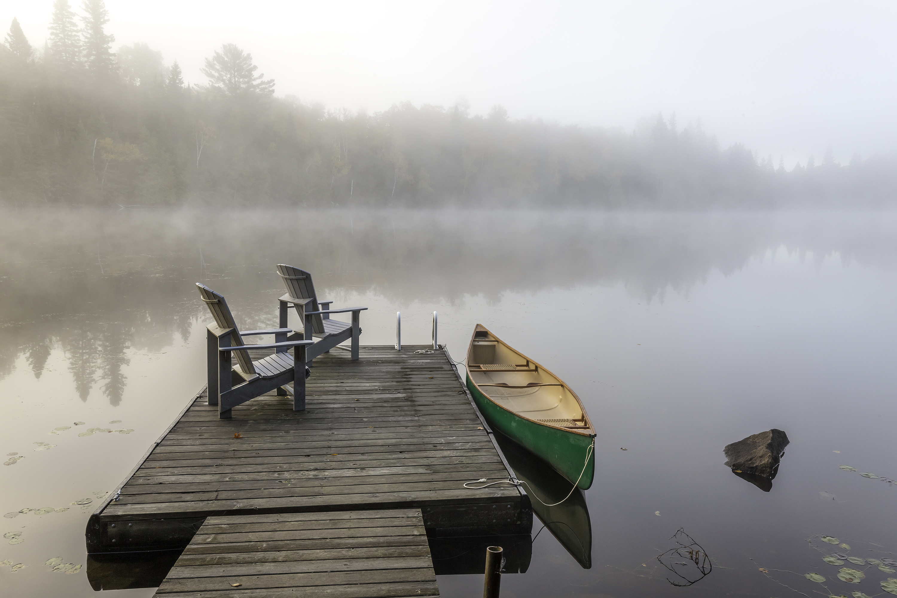 Green Canoe and Dock on a Misty Morning