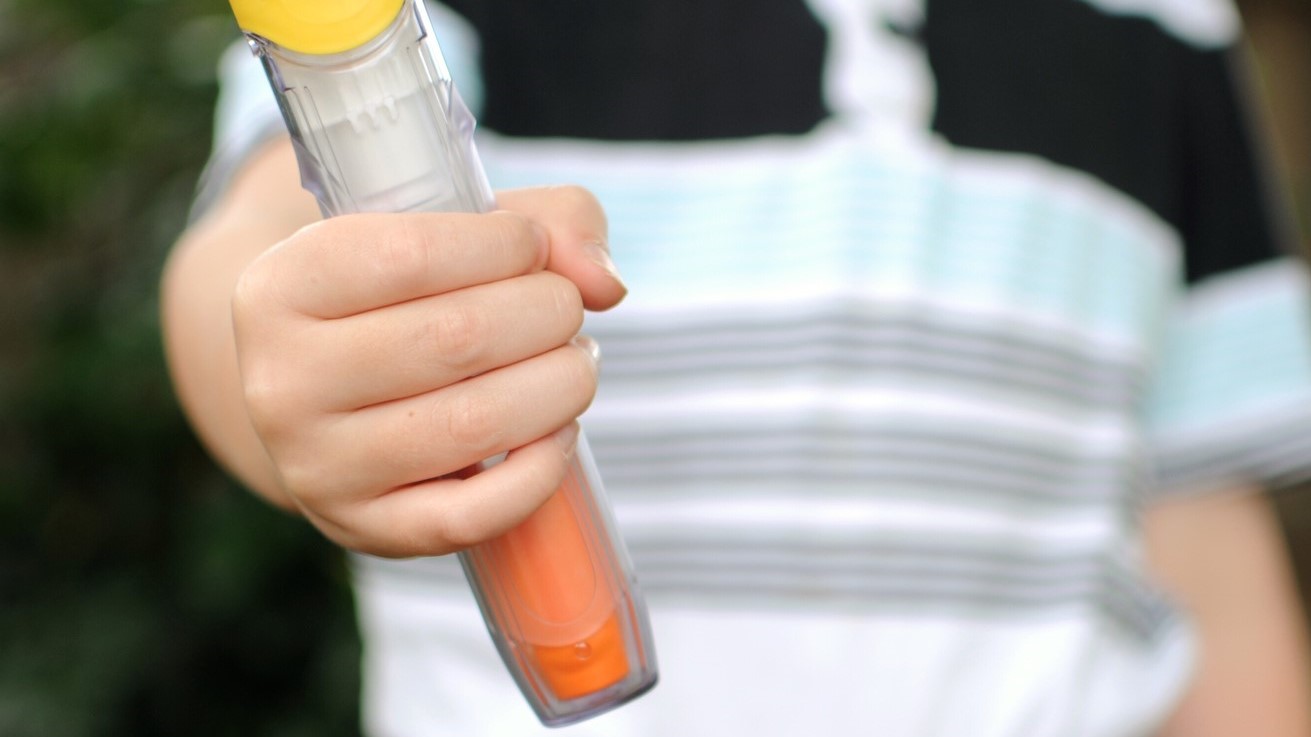 Child holding an auto injector
