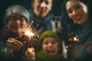 Family having fun, holding sparklers.