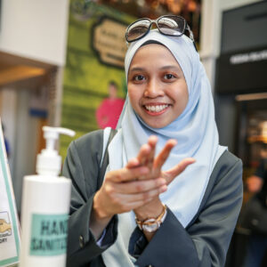 Asian muslim corporate women washing hand using sanitiser